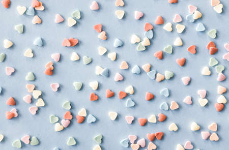 Colorful sugar heart shaped sprinkles on pastel blue background. Valentines day concept. の写真素材