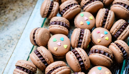 Glass tray with dark chocolate macarons. Modern food concept.の写真素材