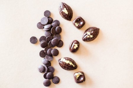 Dark chocolate molded pralines decorated with eatable gold.