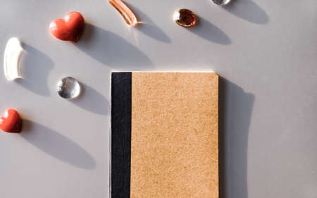 Red hearts, notebook and glass decor on silver background. Valentines day concept. の写真素材