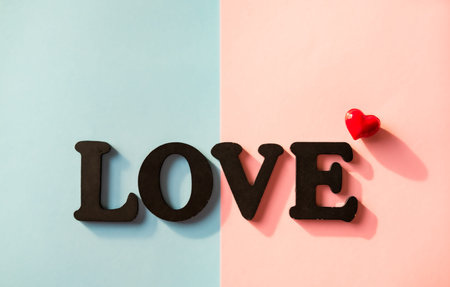 Black word Love and glitters on pink blue background. Valentines day concept background. の写真素材