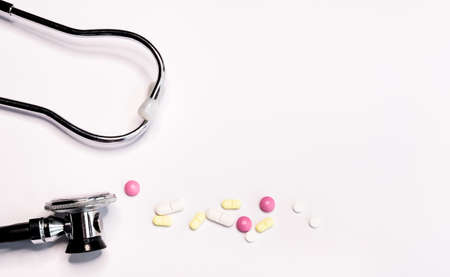 Professional silver black Stethoscope and colorful pills on white background. の写真素材
