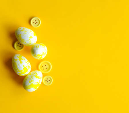 Creative Easter layout. Yellow eggs and buttons flat lay background. Spring holidays concept.の写真素材
