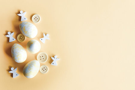 Creative Easter layout. Pastel yellow white eggs and buttons flat lay background. Spring holidays...