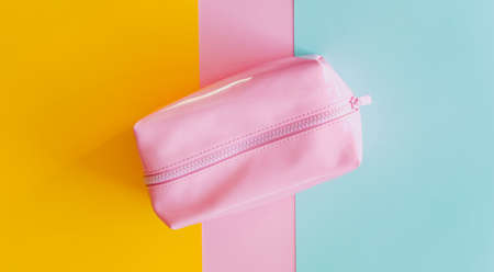 Pink cosmetic bag on pastel colorful background.の写真素材