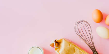 Baking ingredients, flour, milk and eggs on pink background. Food flat lay minimal concept.の写真素材
