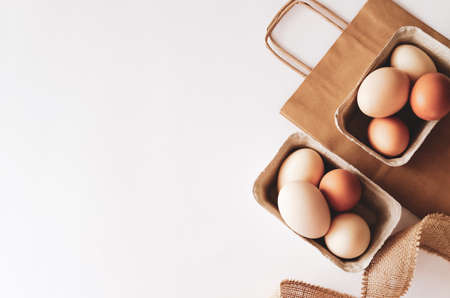 White and brown eggs in reusable paper baskets on light background.の写真素材
