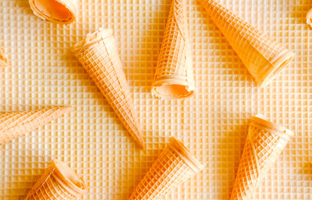 Empty ice cream cones on waffle background. Minimal food concept. 