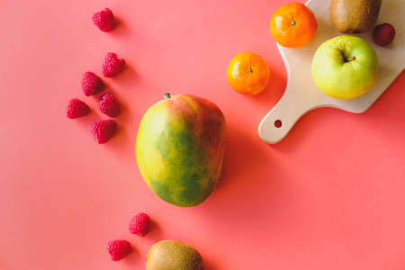 Colorful fruits, mango, raspberries, apple, kiwi, mandarines on vivid pink red background.の写真素材