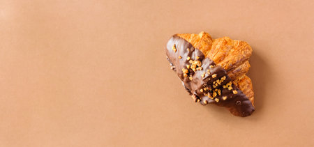Classic dark chocolate croissant on brown background. Sweet food design banner. 