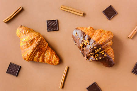 Classic and dark chocolate croissants on brown background. Sweet food design.の写真素材