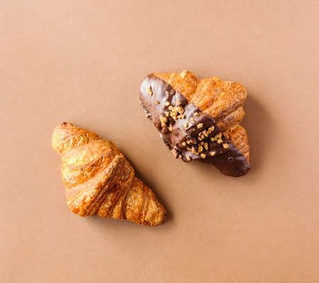 Classic and dark chocolate croissants on brown background. Sweet food design. の写真素材