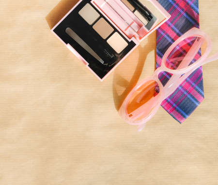 Eyeshadow Make-up multicolor eye shadow palette, pink sunglasses and colorful tie on bright background.の写真素材