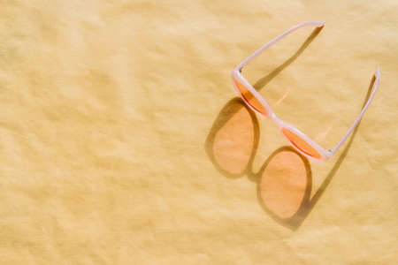 Pastel pink plastic sunglasses on light background. Trendy summer time concept.の写真素材
