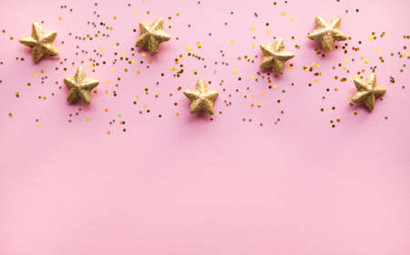 Golden stars glitter over pink background. Festive holiday backdrop.の写真素材