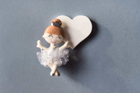 Handmade Princess doll in white silver dress and heart on gray background. Festive minimal concept.の写真素材