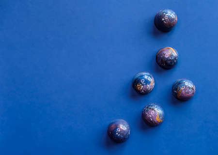Colorful trendy blue molded chocolate pralines on dark background. Modern chocolate design.の写真素材
