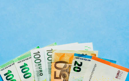 Money in euros closeup, different euro banknotes lying on blue background.の写真素材