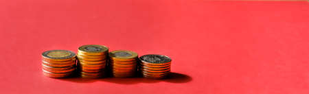 Stacks of coins over red background banner. Saving money concept.の写真素材
