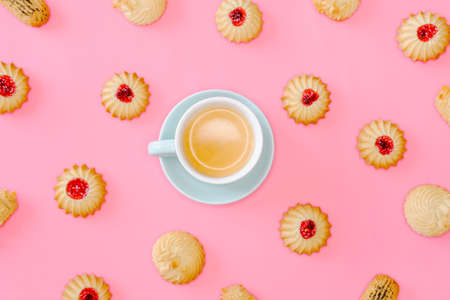 Coffee and cookies with cranberries jam and almonds on pink background. Holidays food concept. の写真素材