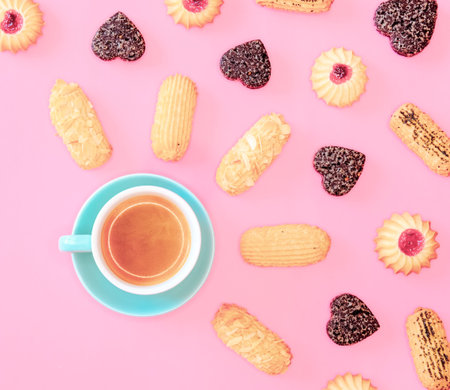 Coffee and cookies with cranberries jam and almonds on pink background. Holidays food concept.
