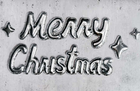 Silver shiny Merry Christmas sign and stars on gray marble background. Festive holidays concept.の写真素材