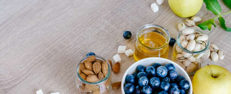 Healthy breakfast set with different nuts, honey or agave syrup and fruits. の写真素材