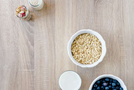 Healthy breakfast set with granola, oatmeal, milk and blueberries on light wooden background. の写真素材