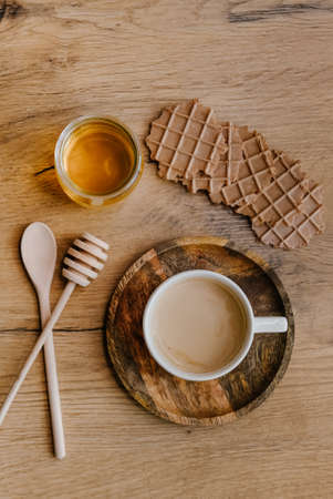 Healthy snack set with coffee and chocolate waffles and honey on wooden background. の写真素材
