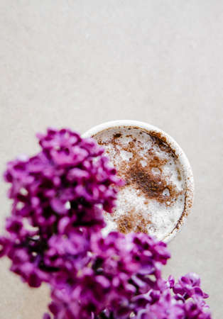 Beautiful vivid lilac flowers and cappuccino on light background. の写真素材