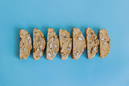 Freshly baked almond biscotti cookies pattern on blue background. Sweet food concept. の写真素材