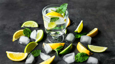 Refreshing iced infused water with lime, lemon and mint on dark background. Summer drink, cocktail concept.の写真素材