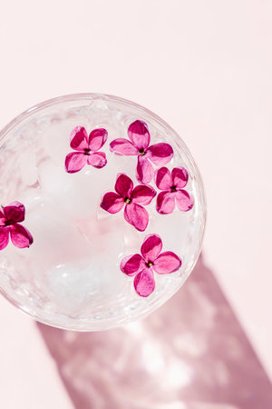 Beautiful vivid lilac flowers in crystal glass on pink background. の写真素材