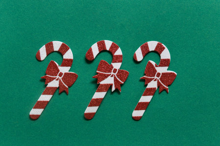 Christmas composition. Christmas candy cane pattern on green background. Happy holidays and new year...