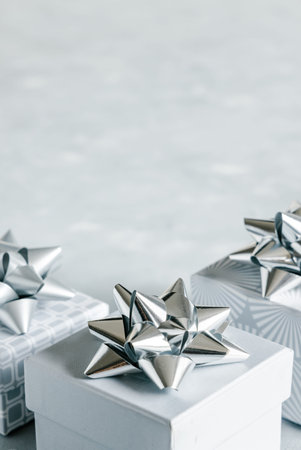 Christmas and New Year holiday monochrome background or greeting card. Gray gift boxes with silver...