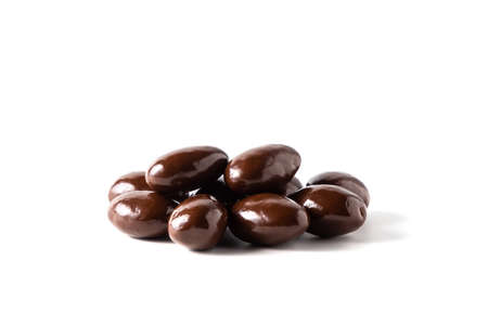 Dark chocolate covered almonds on white background, isolated.の写真素材