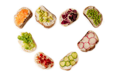 sandwiches or tapas prepared with bread and tasty ingredients. Could be nice food for healthy breakfast ot lunch. Copy space for your text centered in the shape of a heartの写真素材