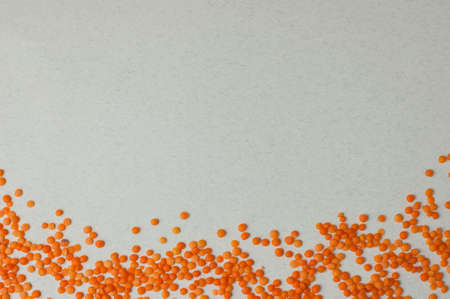 Top view on lentil seeds isolated on a white background.Lentils are rich in vegetable protein and are eaten since prehistoric times.Flat lay with copy spaceの写真素材