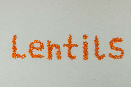 Red lentils inscription on white top view legumes.Lentils are rich in vegetable protein and are eaten since prehistoric times.の写真素材