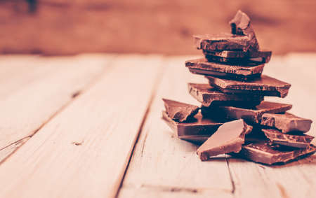 dark chocolate without sugar and gluten free for diabetics and allergics. Broken black chocolate pieces in a pile on a white table in a rustic style. Christmas tree made of chocolate pieces.の写真素材
