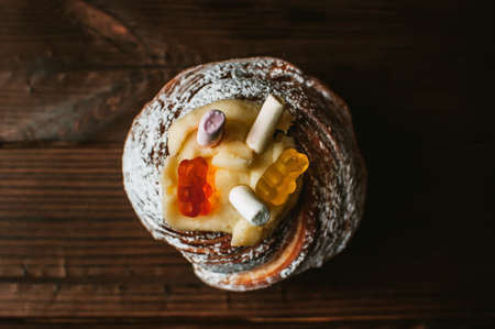 Stylish Easter cake with marshmallows and jelly bears on a dark rustic wooden background, Seasonal greetings for Easter. Copy space. view from above.の写真素材