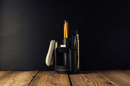 Back to school, the concept of parenting. An assortment of consumables, stands for pens and pencils, an eraser, stationery knives, compasses.Education concept.Copy space. Rustic and vintage toning.の写真素材