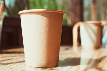 Disposable paper coffee cup on table in cafe with wooden stirrer.Environmentally friendly lifestyle.Zero Waste,Save The Planet,Earth Day,No Plastic,Recycling Conceptの写真素材