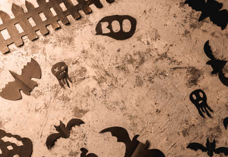 Figures from a black bat and ghosts carved from black paper on a concrete surface. copy space. Crafts for halloween celebration concept. Handwork. Flat layの写真素材