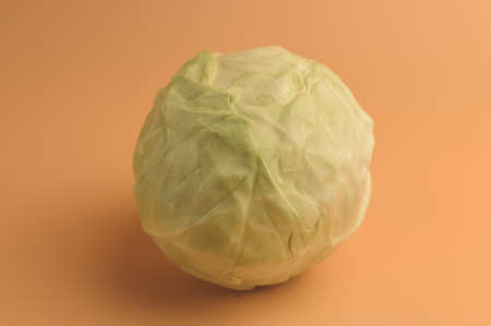 Freshly picked cabbage, on a beige background isolate. Vegetables with an artistic impression. Cabbage for the preparation of soups, salads and snacks. Template for design.の写真素材
