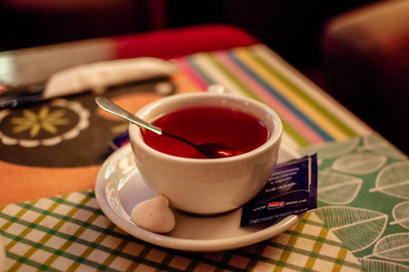 white cup with black tea. A cup of tea stands on a wooden table in a cafe. The concept of a cozy time spent in the fall.の写真素材