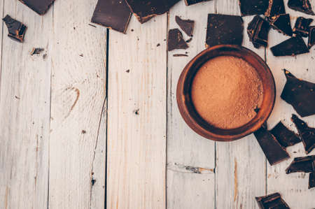 dark chocolate without sugar and gluten free for diabetics and allergics. Pieces of chocolate with crumbs and cocoa powder in the bowl on the right. Concept of healthy eating and diet. Copy space.の写真素材