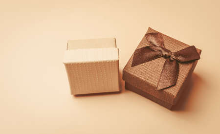 Two vintage beige boxes with a bow on a beige isolated background. Soft toning. Template for design, copy space.の写真素材