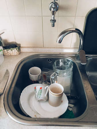 a sink full of dirty uncleaned dishes. Trend cleanliness and order.の写真素材