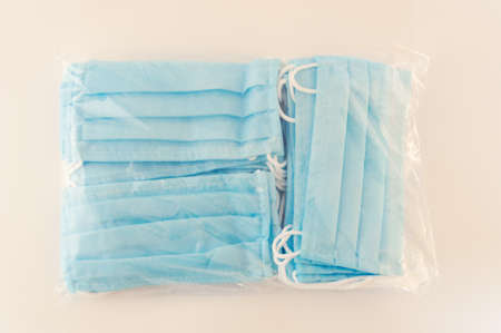 Protective medical masks are sealed in a package on a table in a pile.の写真素材